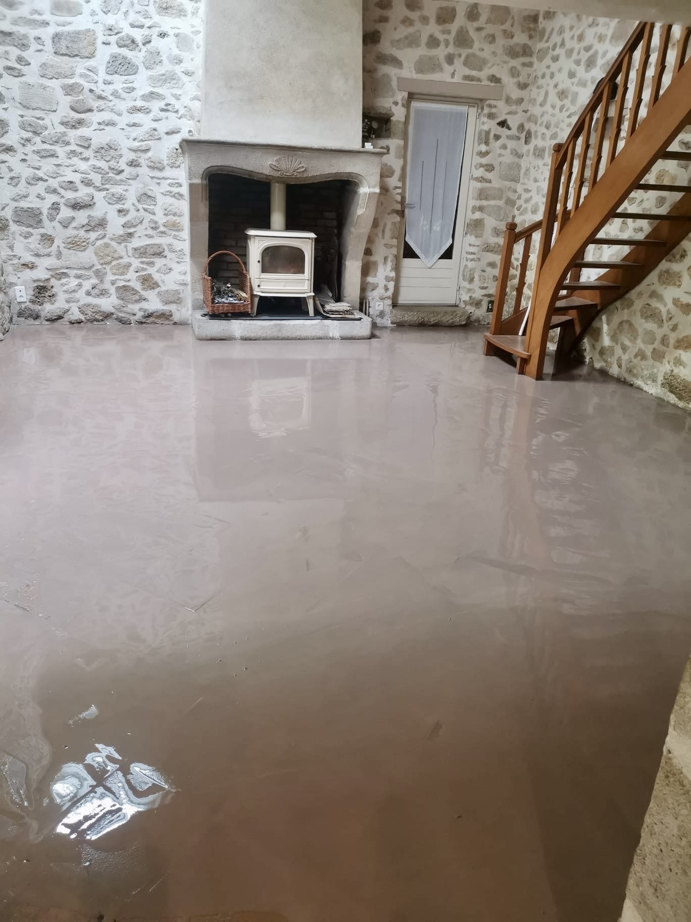 Séjour avec sol en béton ciré et cheminée avant pose du parquet