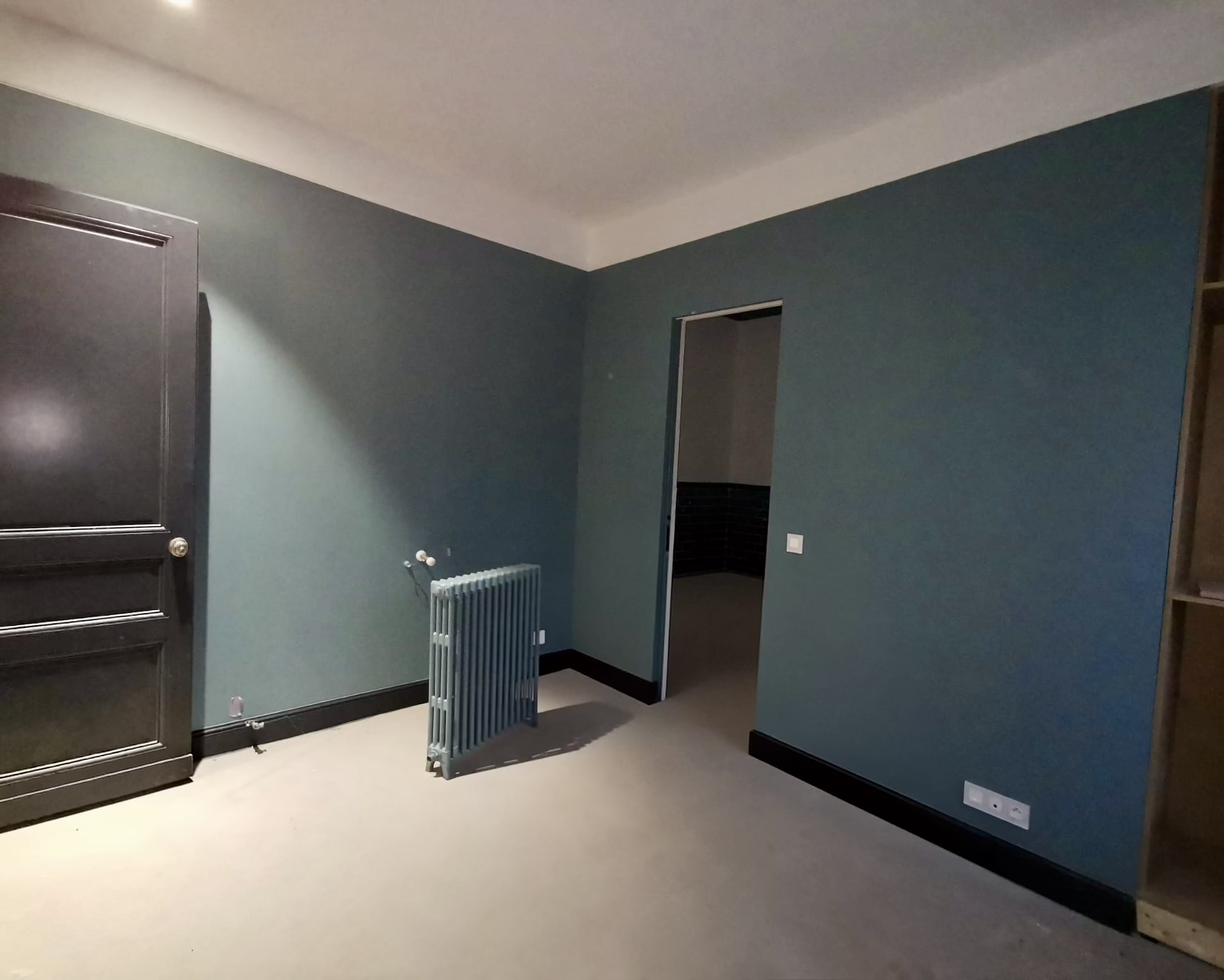Chambre peinte en vert foncé avec plinthes noires à Bordeaux