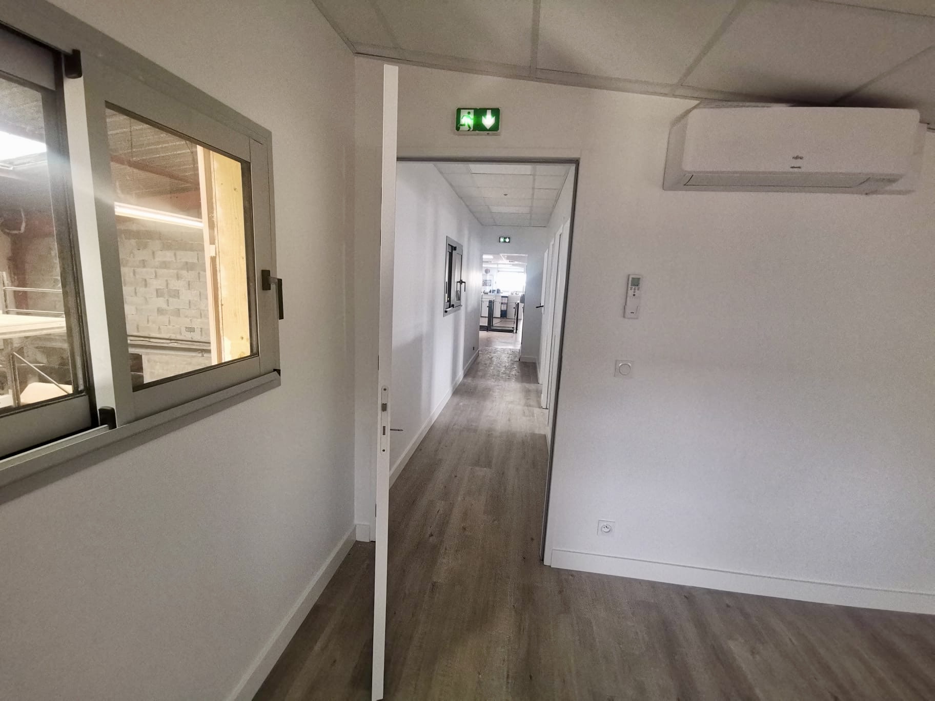 Couloir de bureaux rénové avec faux-plafond et climatisation à Bordeaux