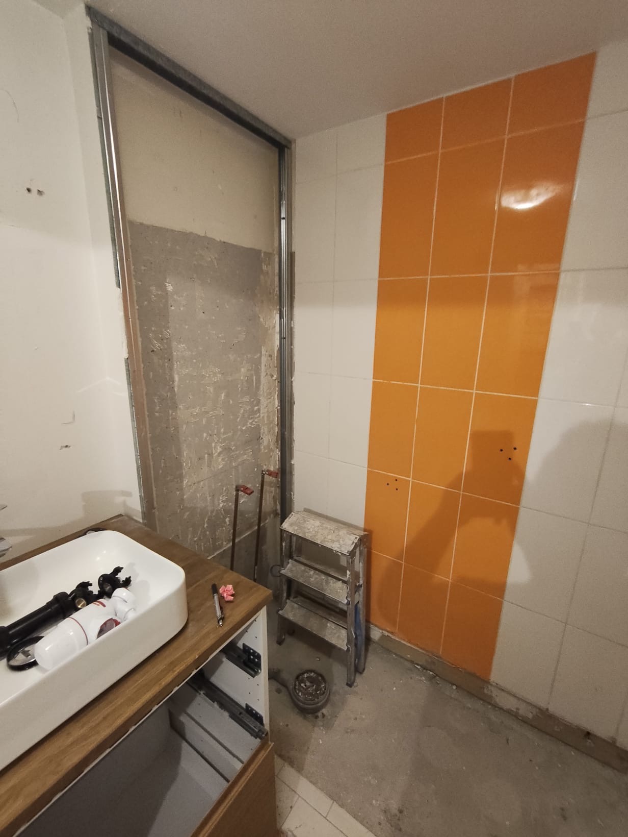 Dépose de l'ancien carrelage orange avant rénovation de la salle de bain