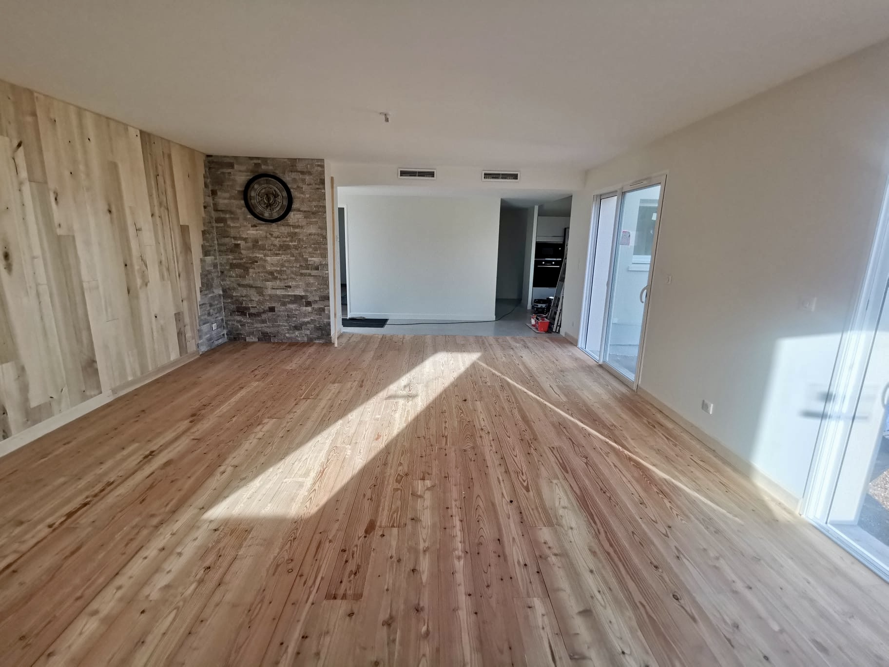 Salon avec parquet en pin et parement pierre posés à Bordeaux