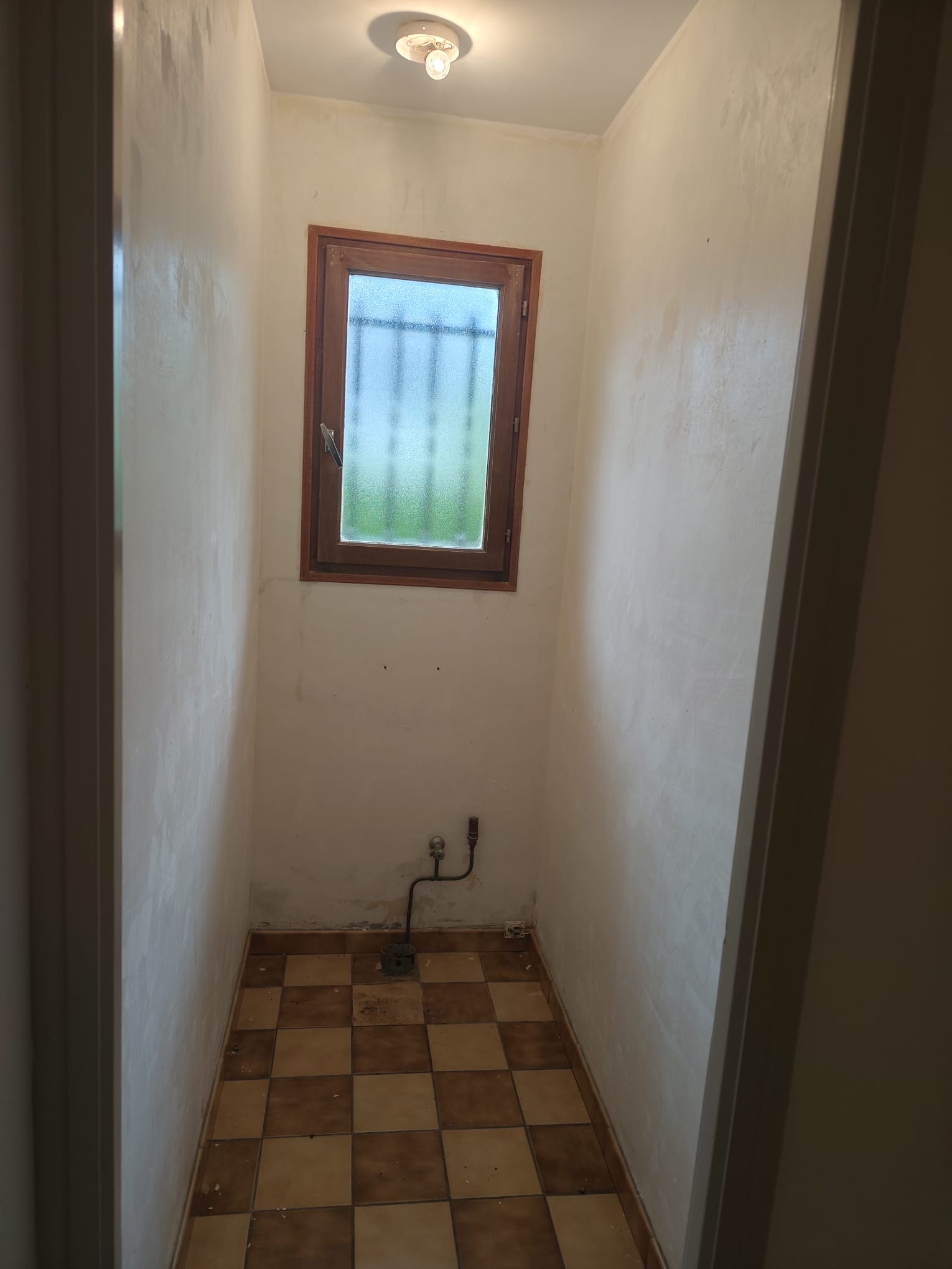 Anciens WC avec carrelage en damier avant rénovation